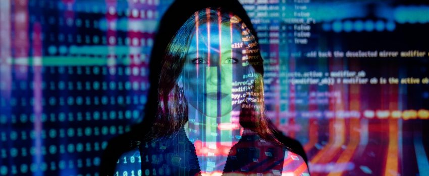 Headshot of Woman in sleeveless top with a projection of computer code over her face.